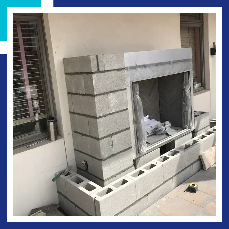 A fireplace is being built outside of the house.