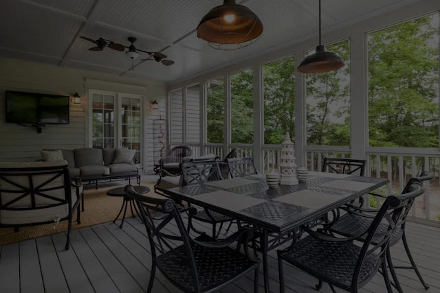 A table and chairs in the middle of a porch.