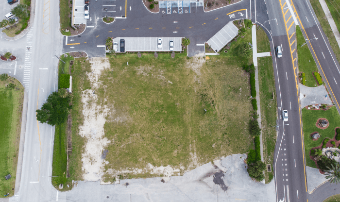 An aerial view of a parking lot and a field.