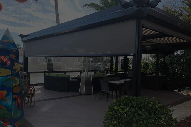 A patio with tables and chairs under an awning.