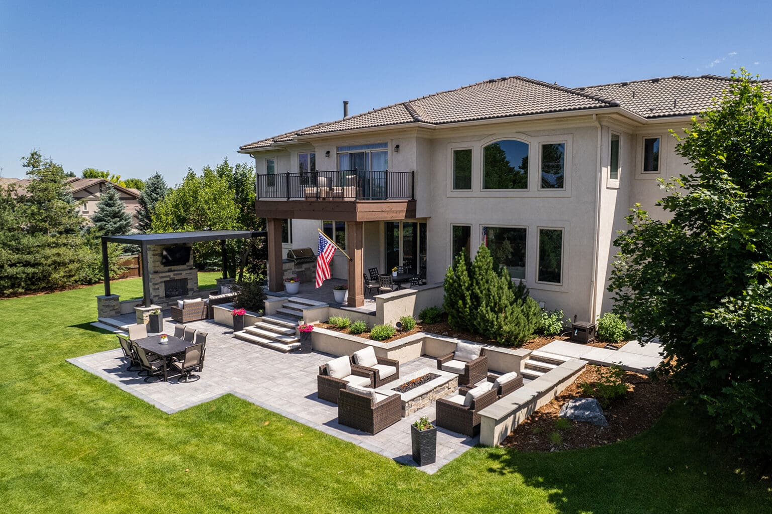 A large backyard with a patio and outdoor furniture.