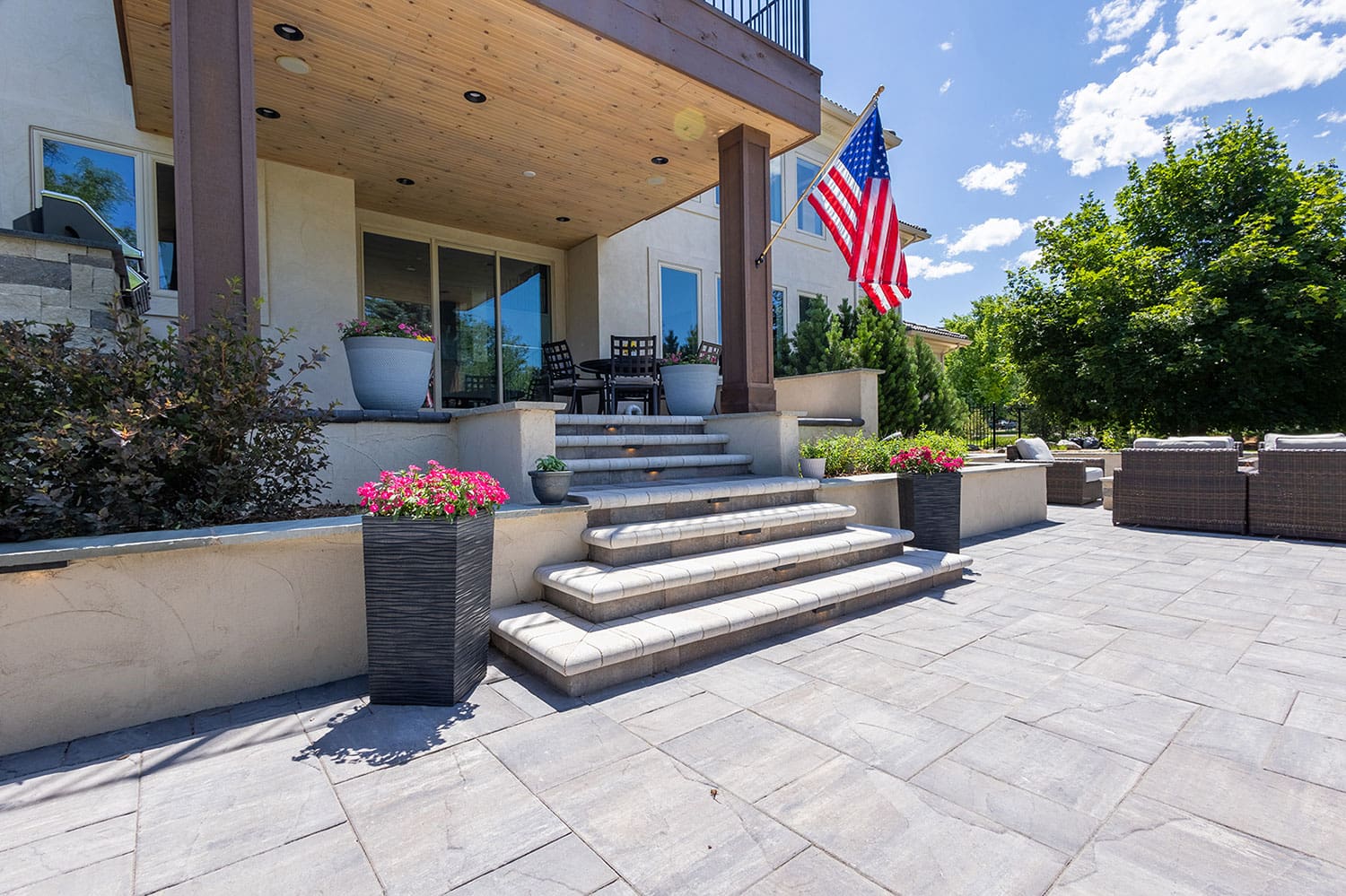A large patio with stairs leading to the front of a house.