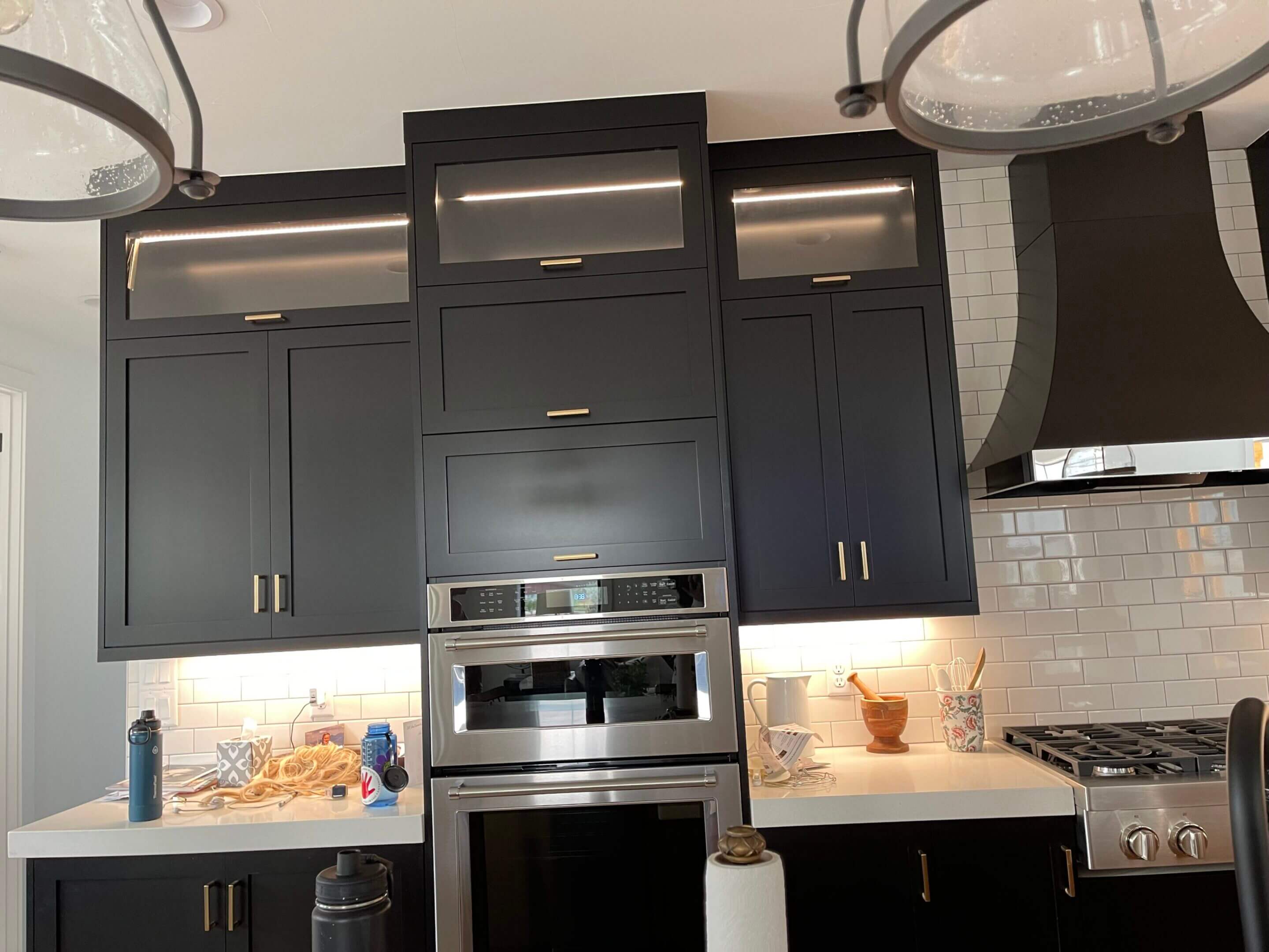 Modern dark kitchen with stainless steel appliances.