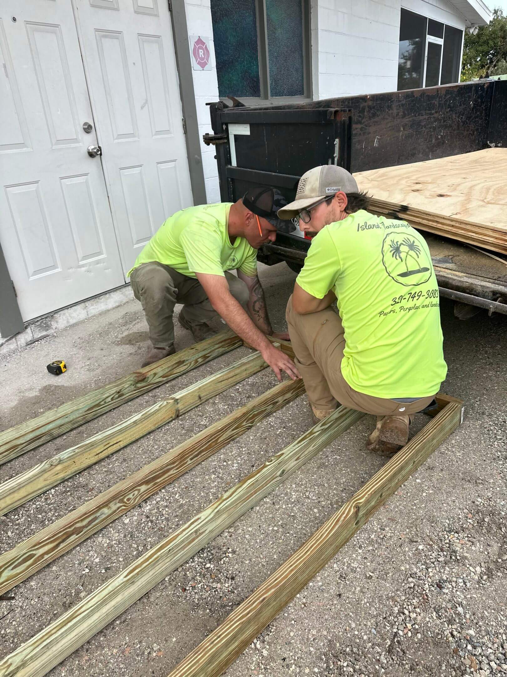 Two workers building a wooden frame.