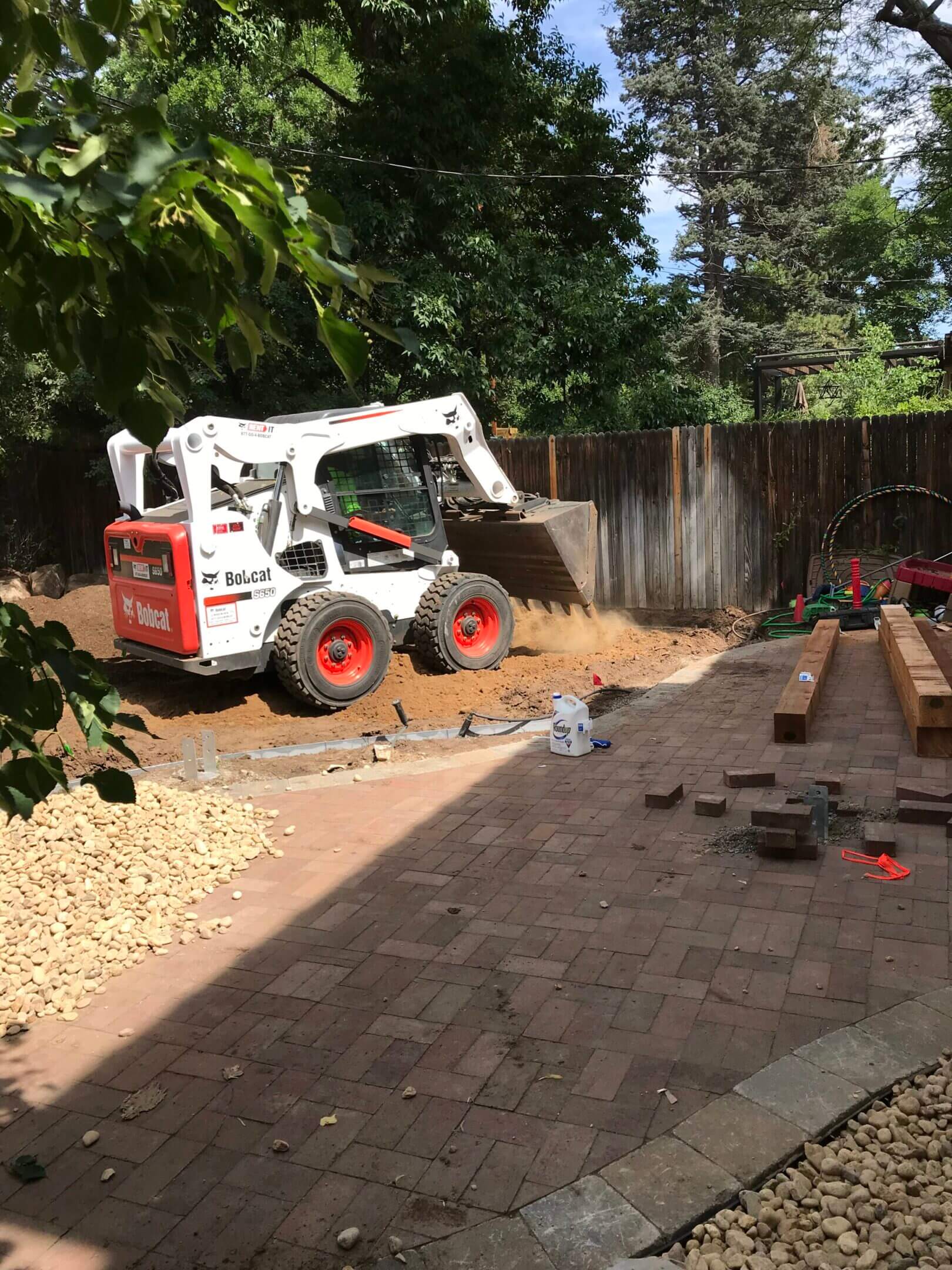Bobcat skid steer moving dirt.