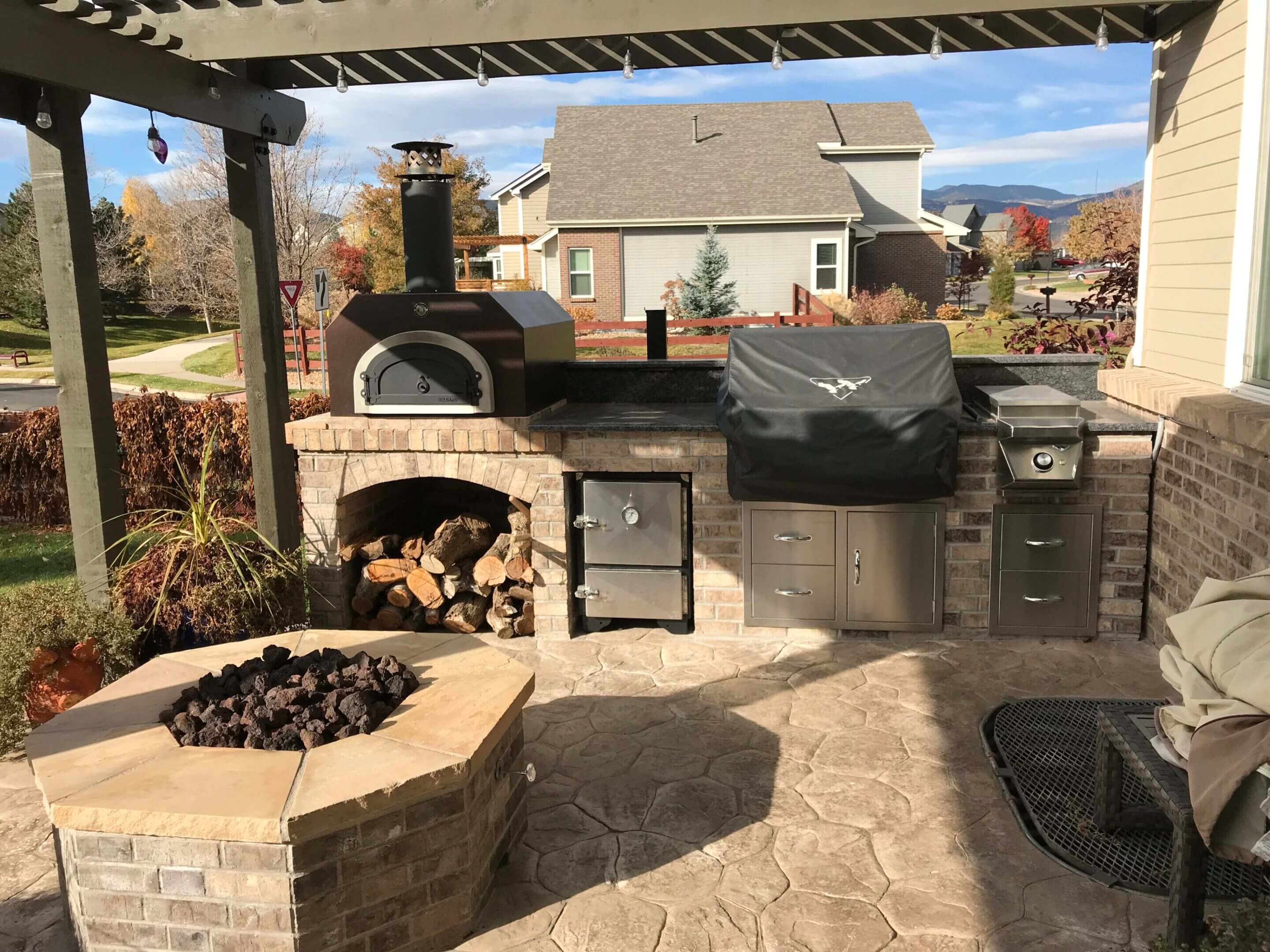 Outdoor kitchen with pizza oven and grill.