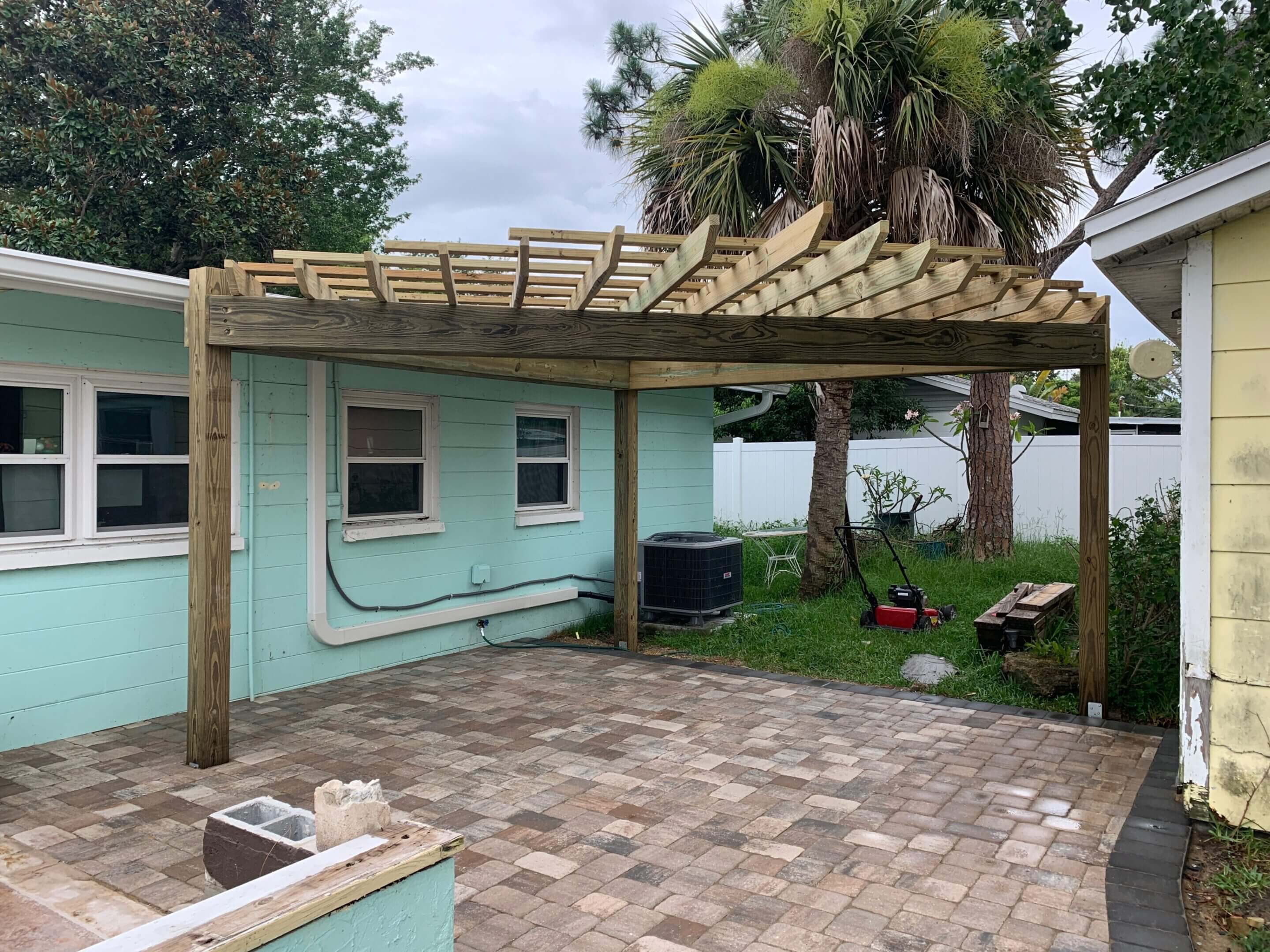 Wooden pergola attached to house patio.