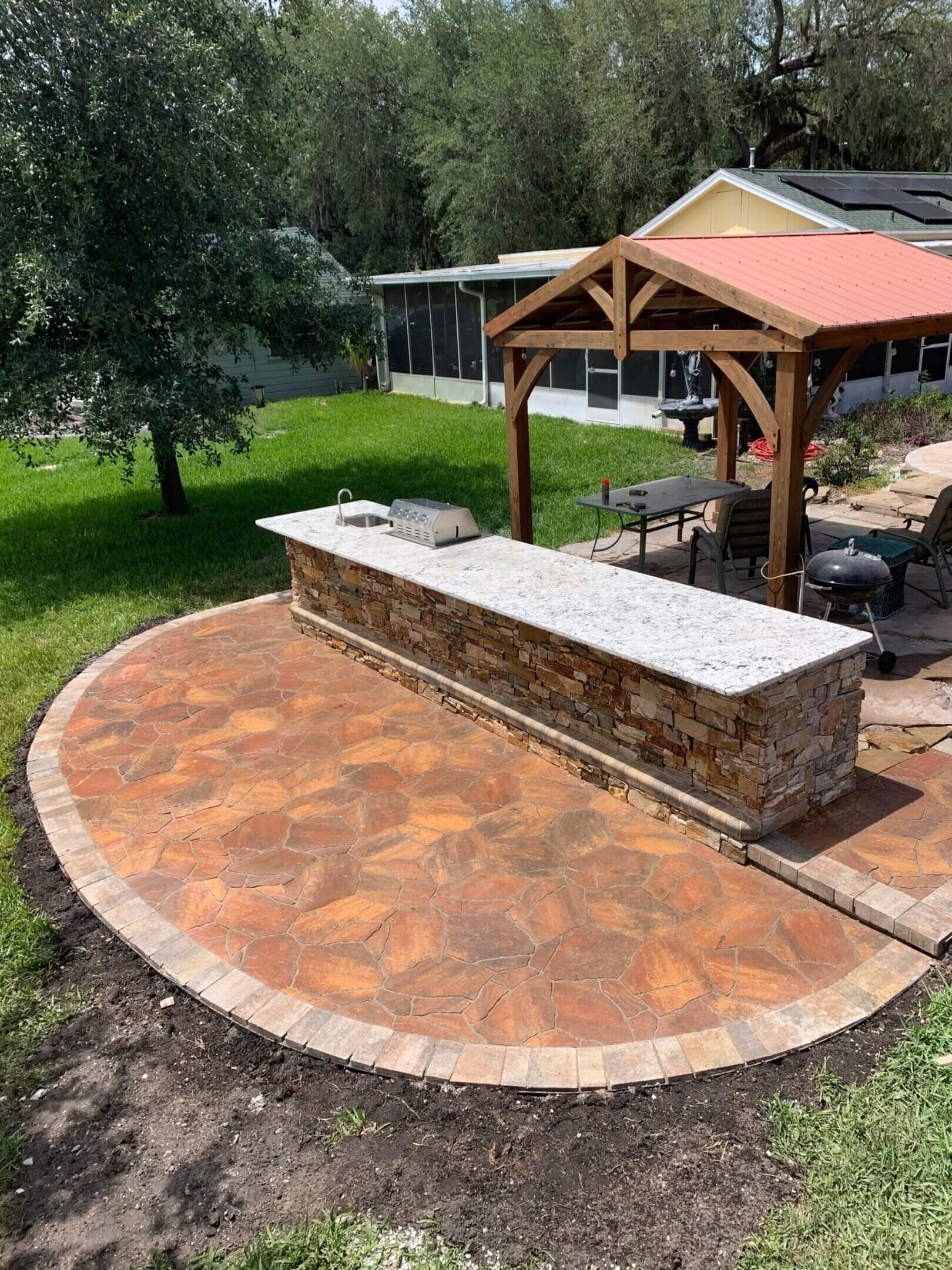 Outdoor kitchen with granite countertop.