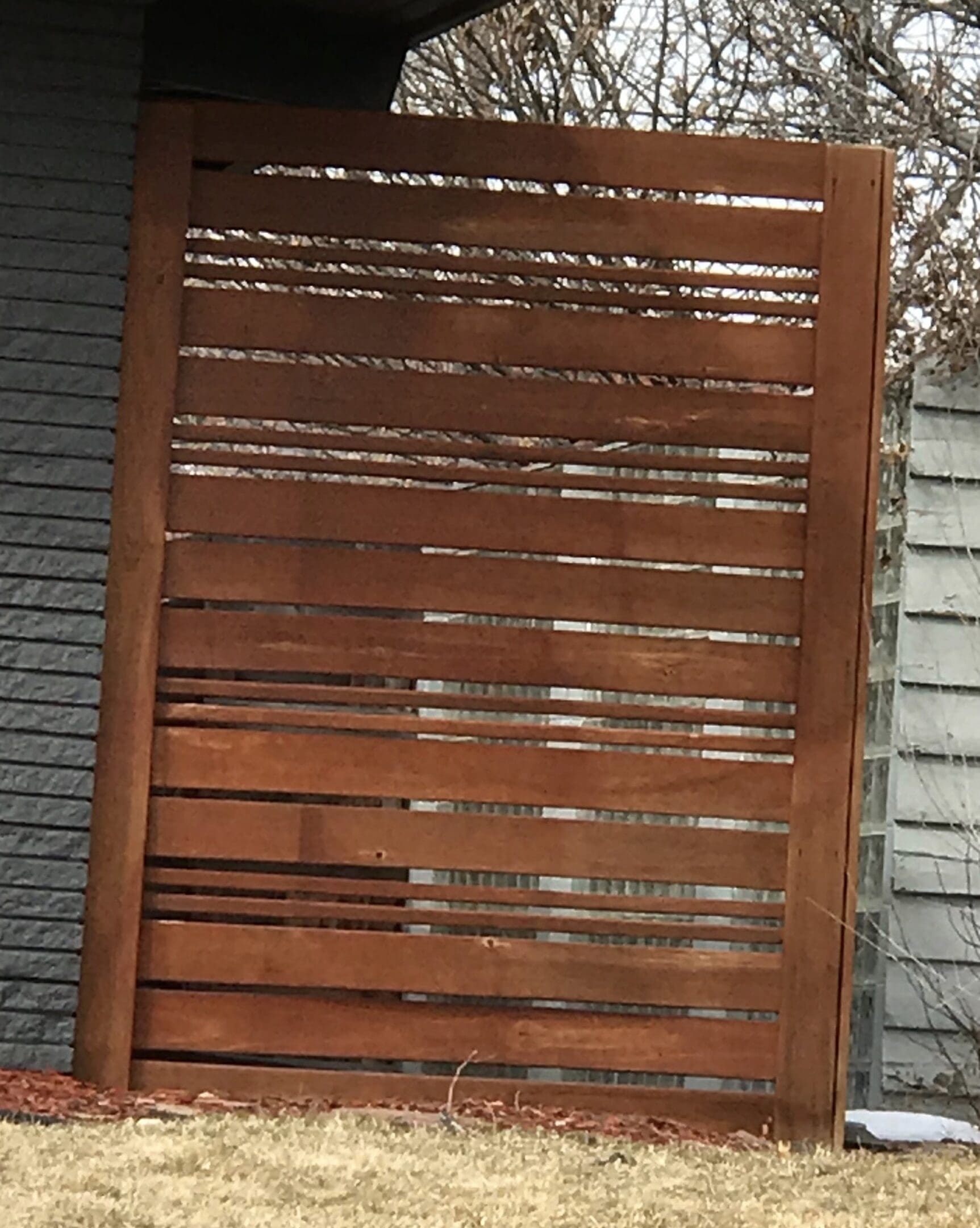Brown wooden slat fence panel.