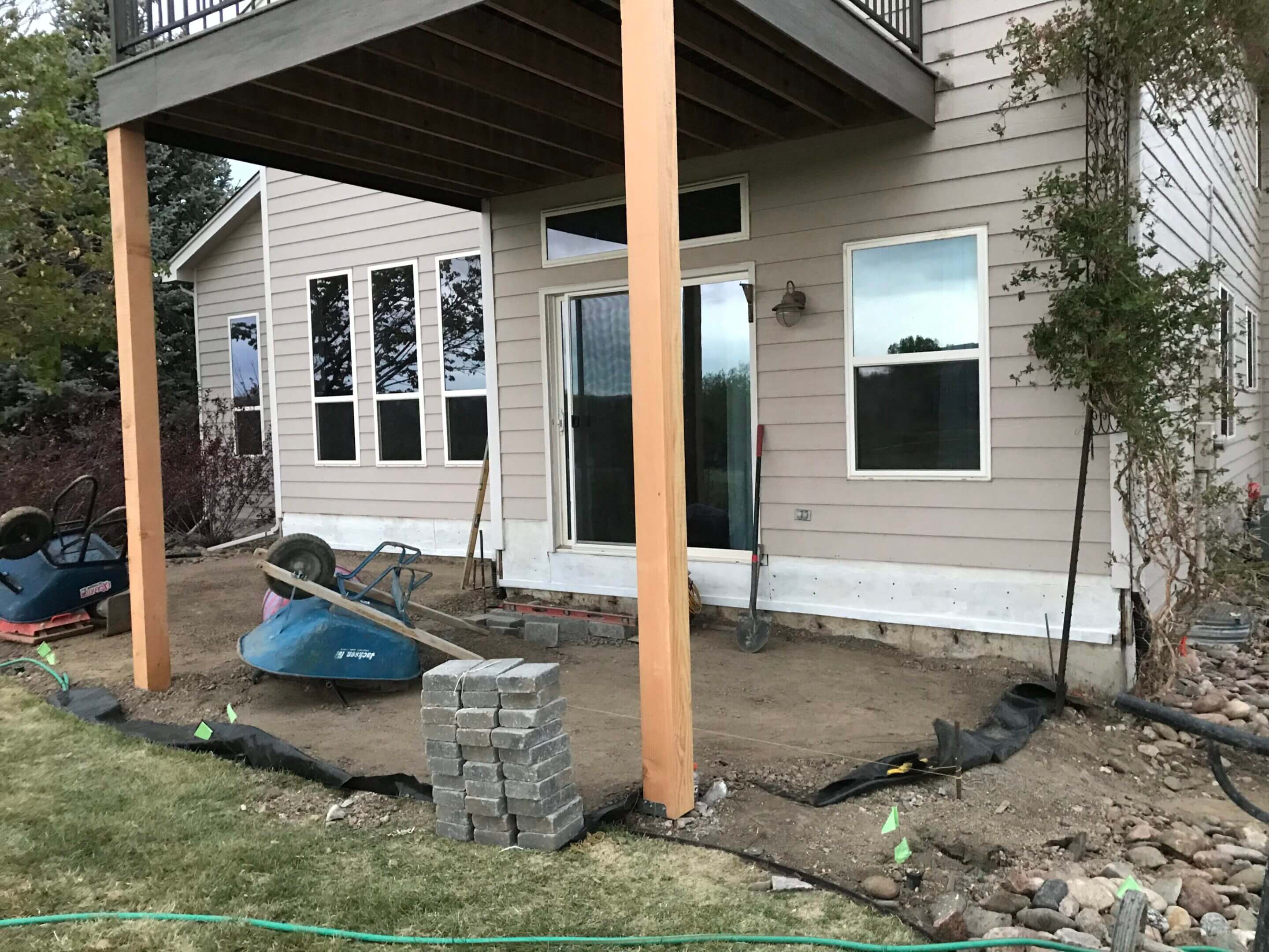 Patio construction underway, house exterior.
