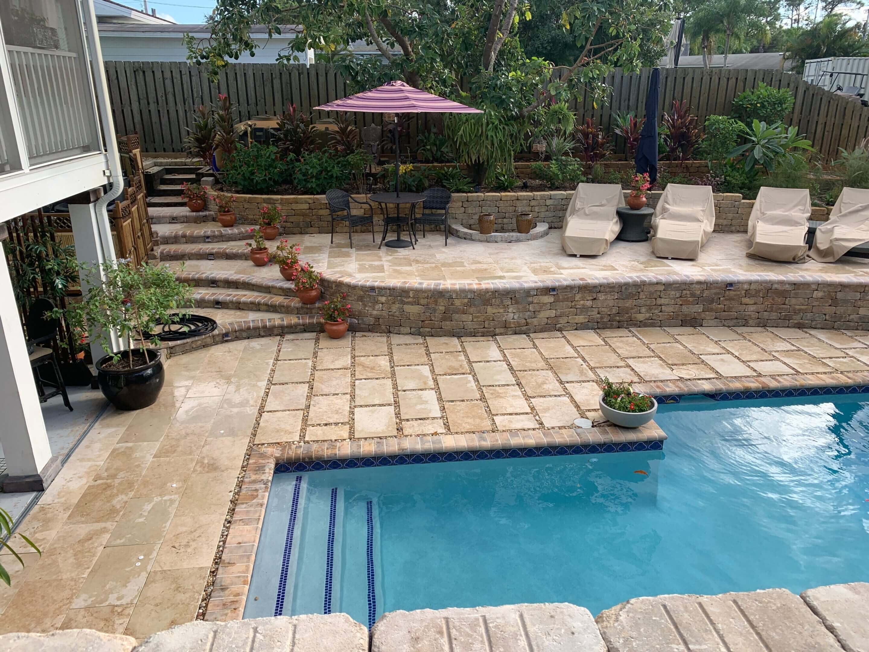 Backyard pool with patio and seating.