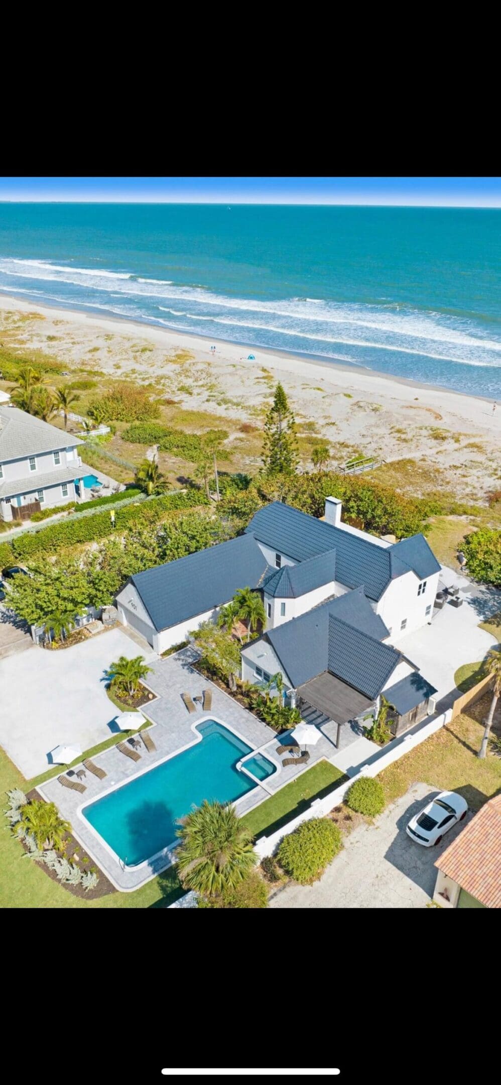 Here's an alt tag for the image: Oceanfront home with pool.