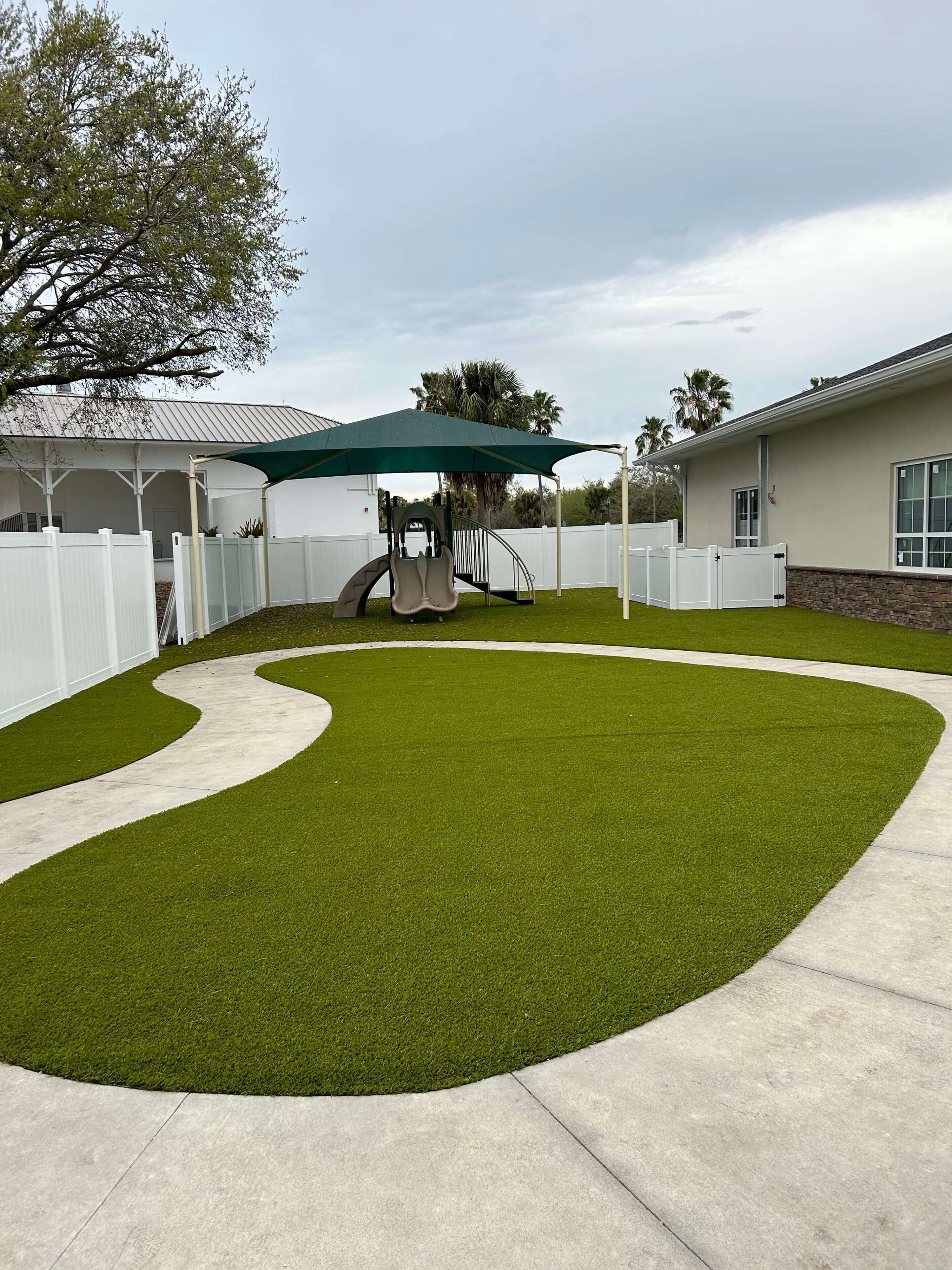 Playground with slide and shaded turf.