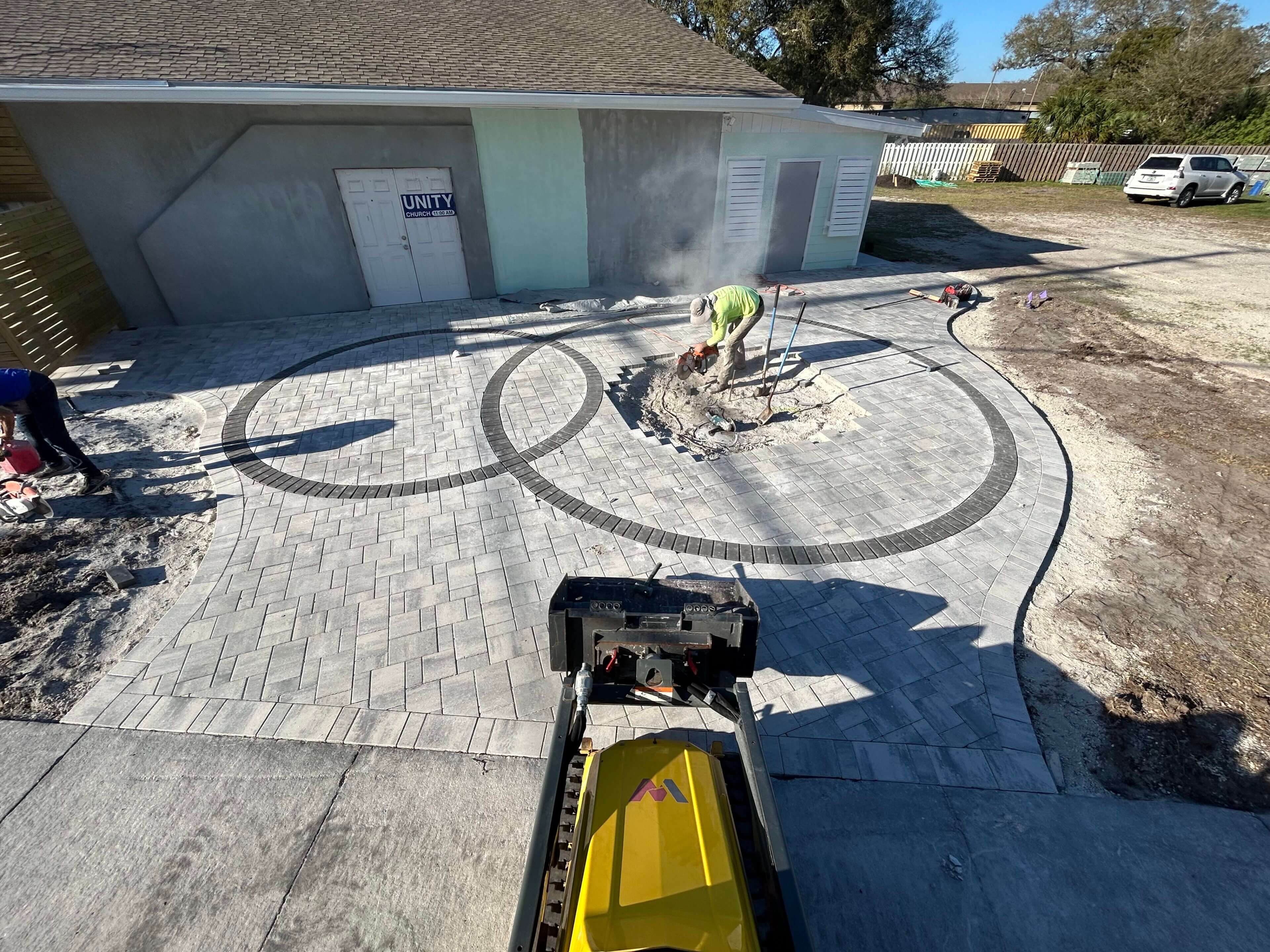 Here's an alt tag for the image: `Paver patio installation in progress`