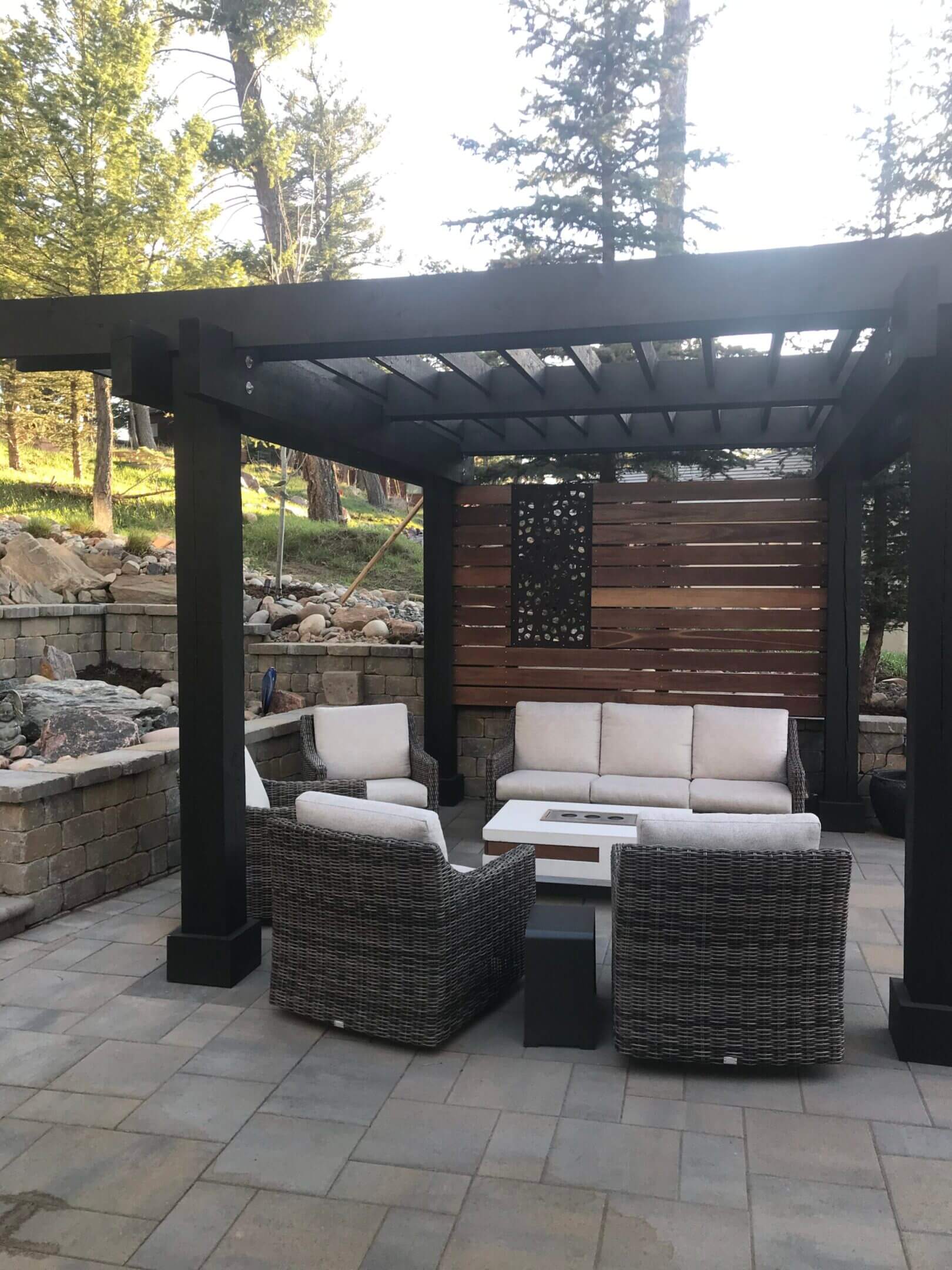 Patio furniture under a wooden pergola.
