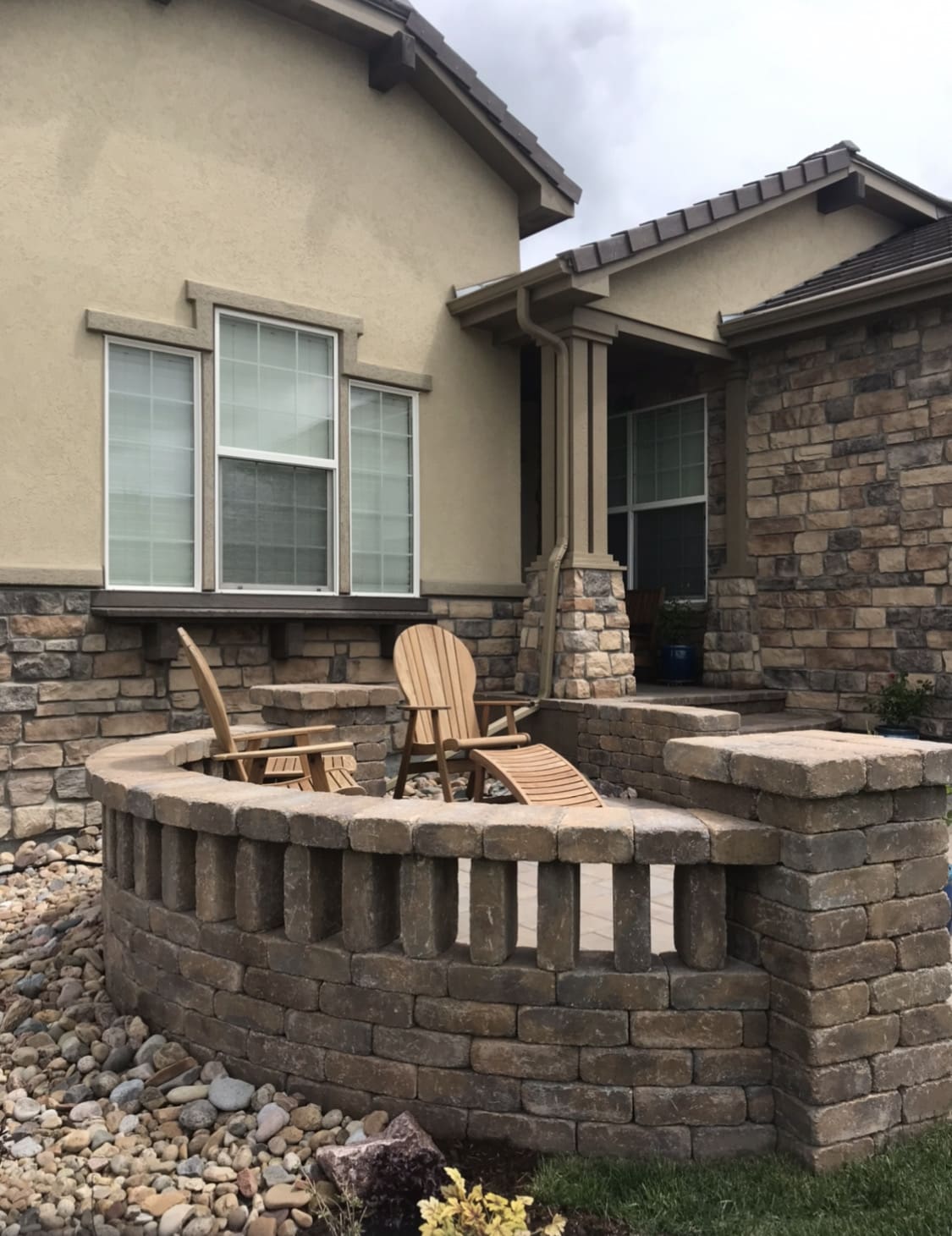 Stone patio wall with Adirondack chairs.