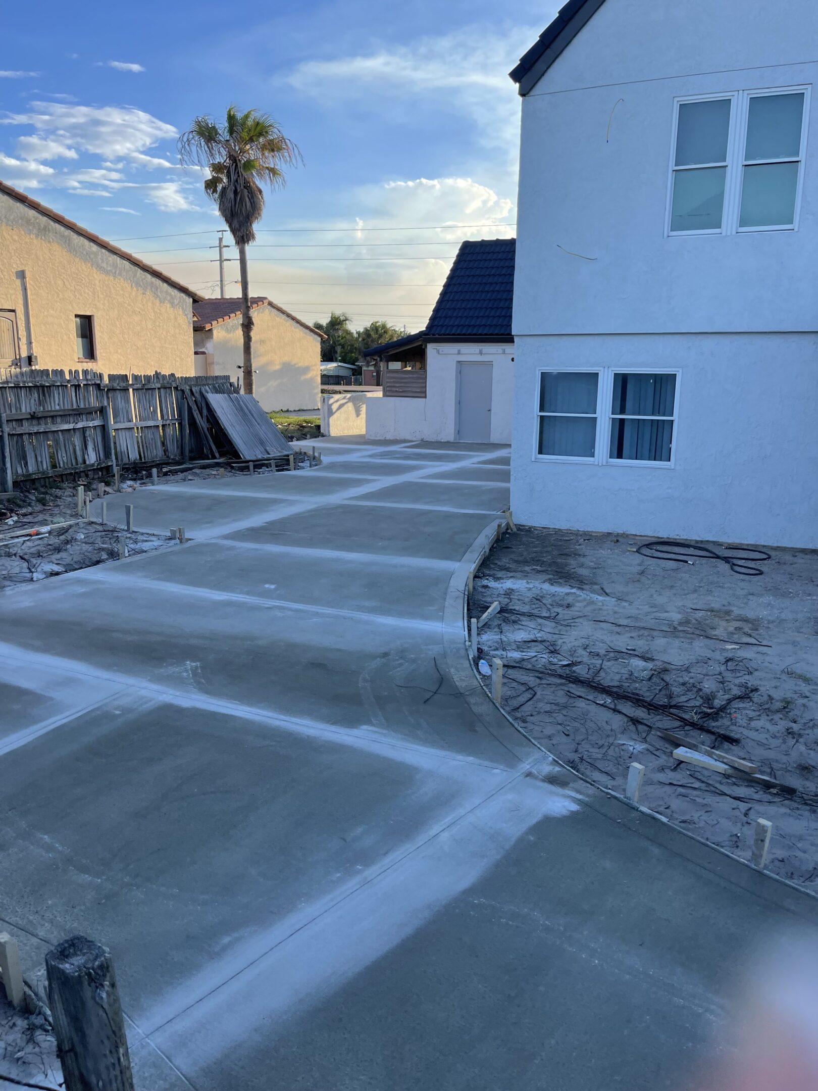 Newly poured driveway next to house.