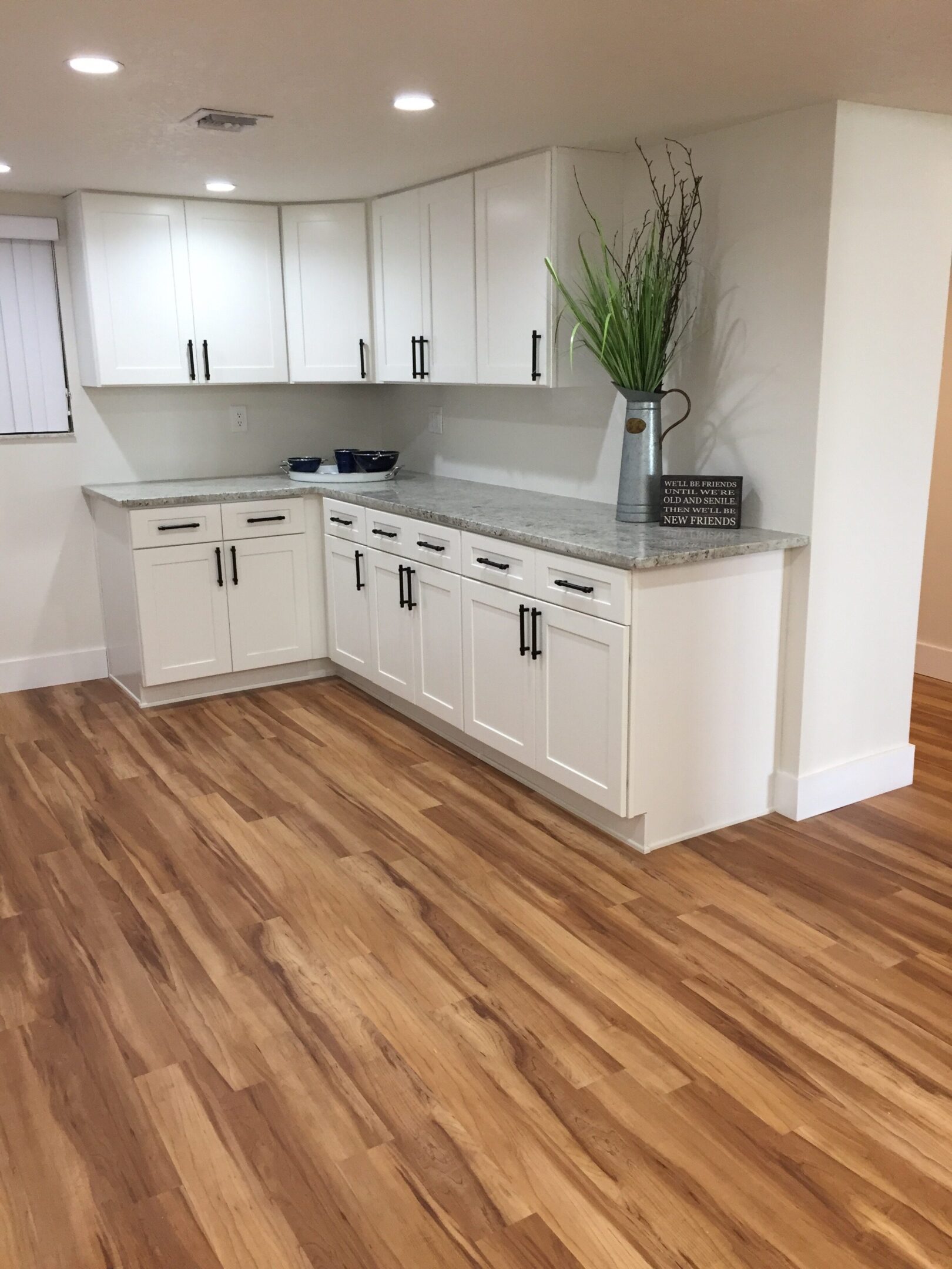 White kitchen cabinets, wood floor.