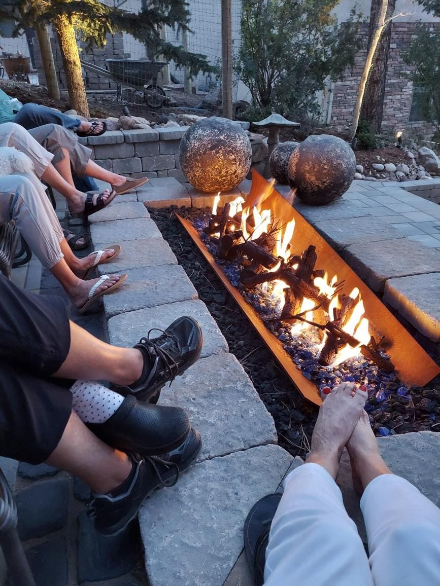 People warming feet by fire pit.